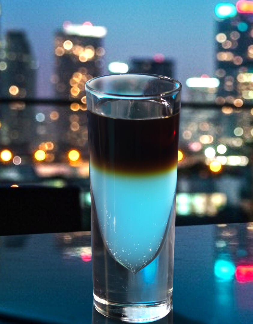 Shot de Hpnotiq con el paisaje nocturno de la ciudad al fondo